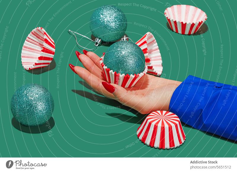 Eine Weihnachtskugel von Hand überreichen Weihnachtsgeschenk rote Nägel Kugel Frau anonym türkis Glitter Weihnachten Cupcake-Einlage gestreift Präsentation