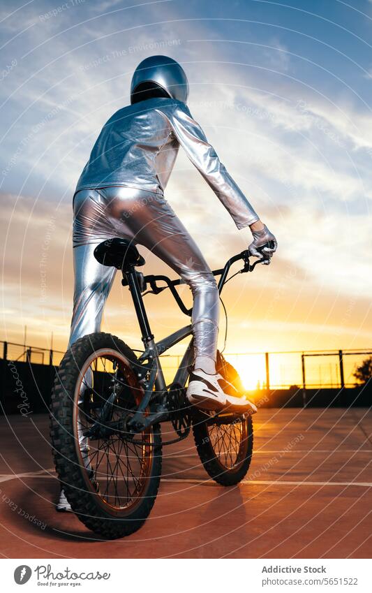 Unbekannter Stuntman führt abends Kunststücke auf dem Fahrrad vor Tracht Sicherheit Erholung unkenntlich wolkig Schutzhelm Ganzkörper Sonnenuntergang Aktivität