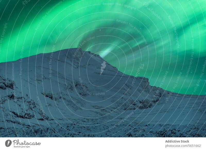 Malerischer Blick auf eine schneebedeckte Bergkette vor blauem Himmel mit grünem Polarlicht im Winter Berge u. Gebirge Schnee Nordlicht Ambitus grüner Himmel