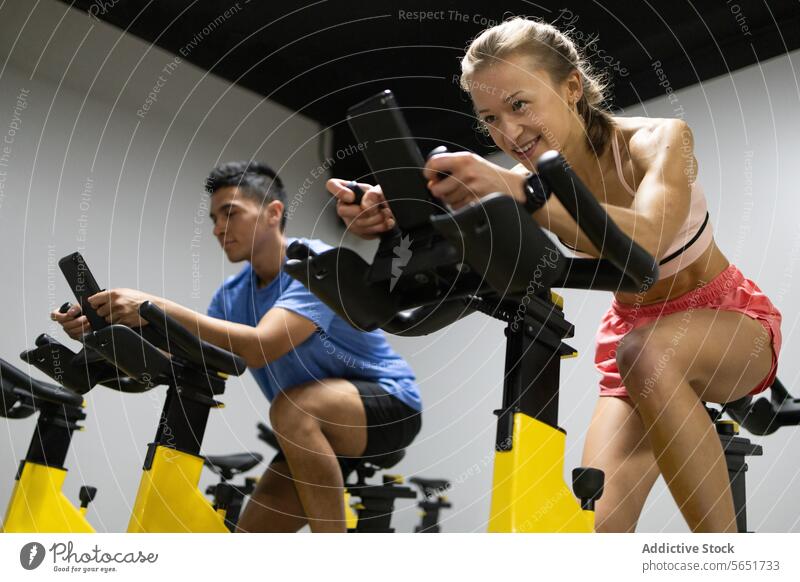 Energiegeladene Teilnehmer eines Spinning-Kurses radeln im Fitnessstudio Gesundheit Übung Fahrradfahren Sport Training Ausdauer Stärke Herz im Innenbereich