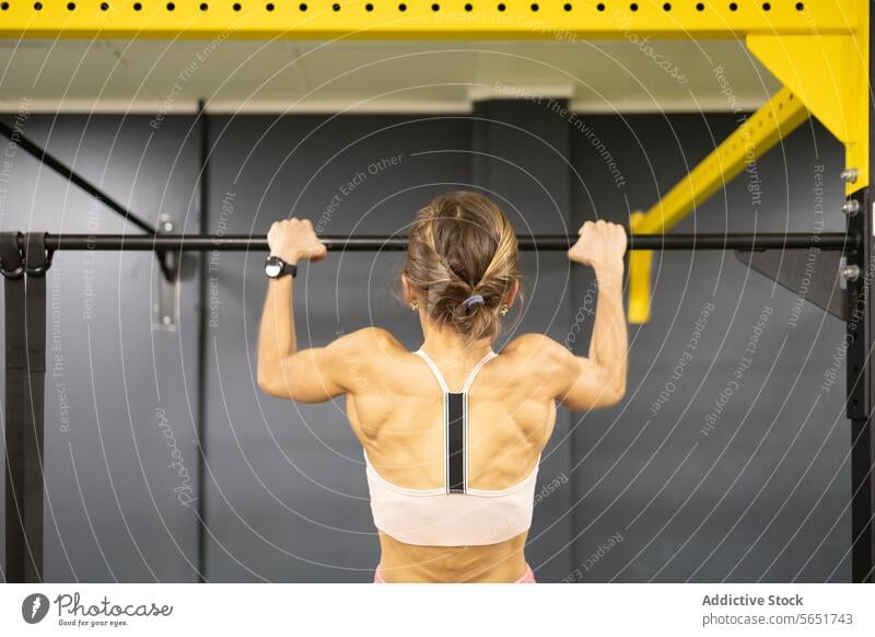 Frau trainiert an der Klimmzugstange im Fitnessstudio Übung Stärke Ausdauer Training Gesundheit muskulös Tonung Bar Sport physisch Aktivität Gesunder Lebensstil
