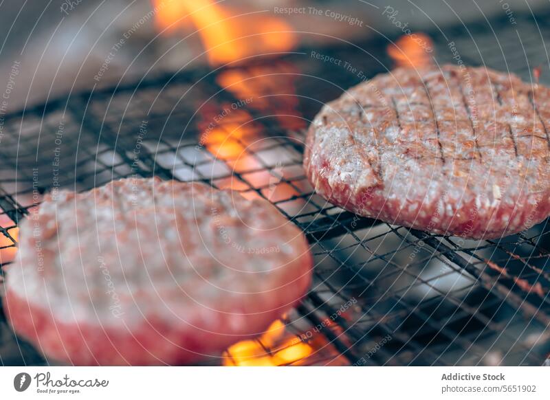 Saftige, über offener Flamme gegrillte Hamburger Grillrost Barbecue Essen zubereiten Lebensmittel Nahaufnahme Fleisch Rindfleisch saftig verkohlt Mahlzeit