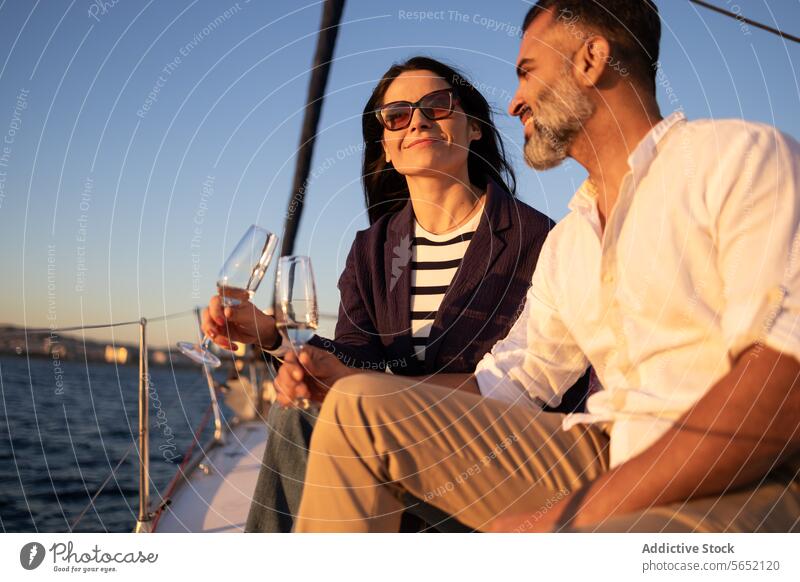 Lächelndes Paar stößt mit Weingläsern in einer Jacht auf dem Meer an Klirren Liebe romantisch MEER Zuprosten Glück Strand Weinglas Alkohol Termin & Datum Resort