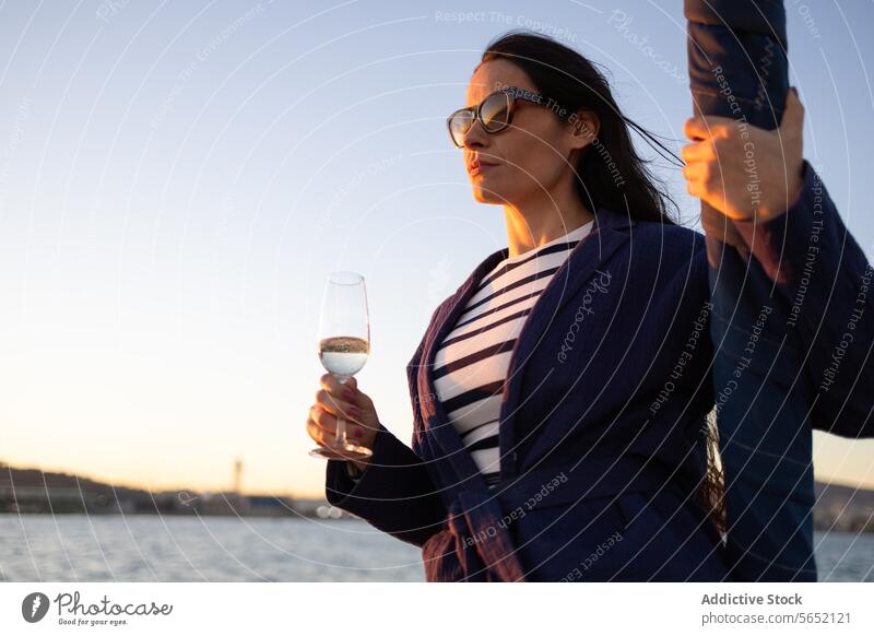 Junge Frau mit Glas Getränk am Meer stehend MEER Wasser Jacht Outfit Segelboot Ufer Tourismus idyllisch modern Boot aqua trinken Rippeln Küste übersichtlich