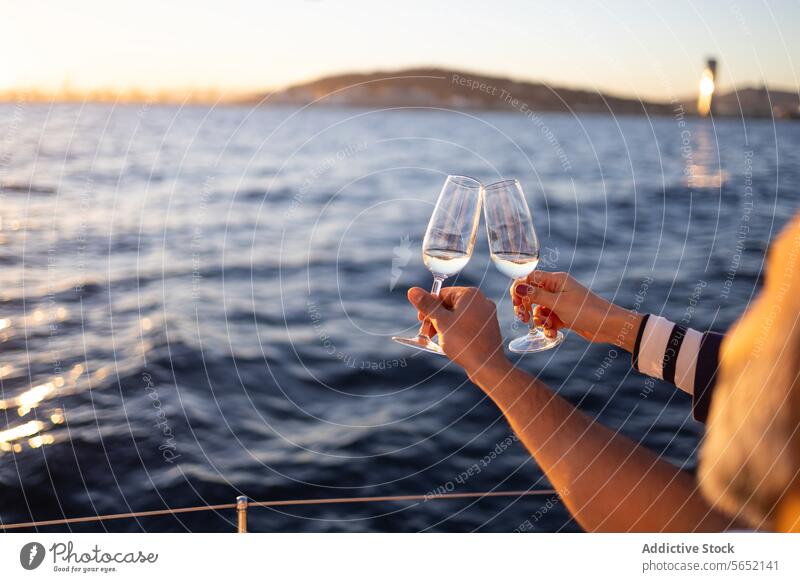 Anonymes Paar stößt mit Weingläsern in einer Jacht auf dem Meer an Klirren Liebe romantisch MEER Zuprosten Strand Weinglas Alkohol Termin & Datum Resort trinken