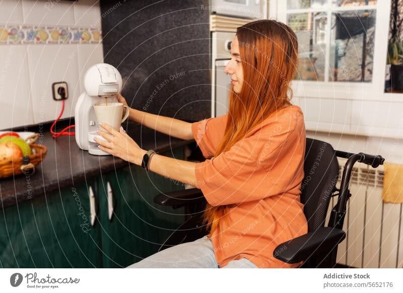 Inklusives Leben - Frau im Rollstuhl kocht zu Hause Kaffee Maschine Küche heimwärts Zugänglichkeit Selbstständigkeit Vorbereitung trinken Haushalt Vorrichtung