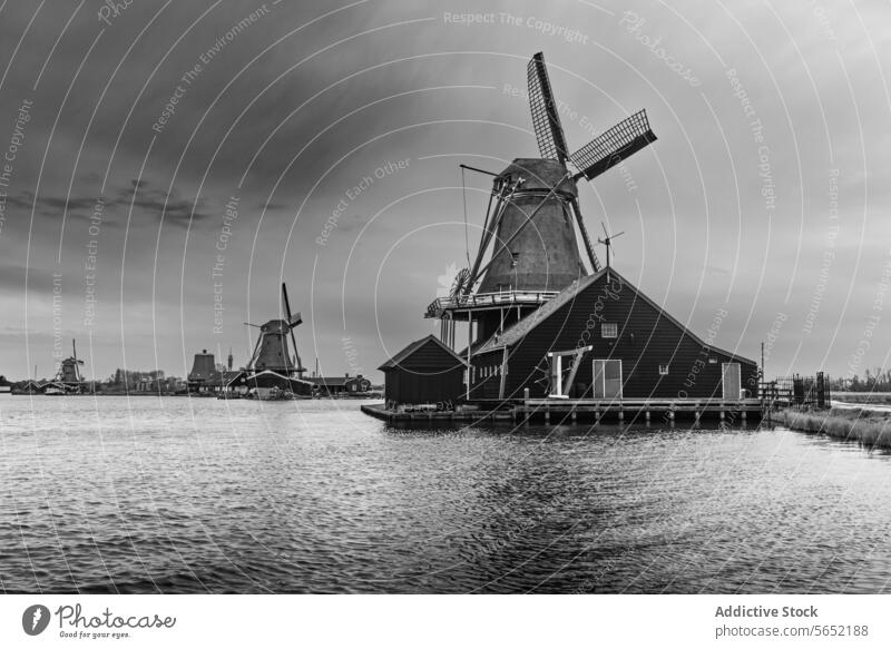 Schwarz-Weiß-Bild von ikonischen Windmühlen am Wasser in dem historischen Dorf Zaanse Schans, Niederlande schwarz auf weiß zaanse schans holländisch Architektur