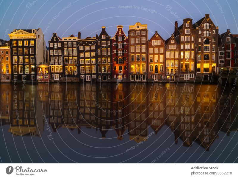Die goldene Stunde spiegelt sich in den ikonischen Amsterdamer Grachtenhäusern, die sich perfekt im stillen Wasser spiegeln Reflexion & Spiegelung Niederlande