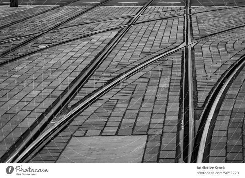 Komplexes Netz von Straßenbahnschienen, die sich auf Kopfsteinpflasterstraßen in Schwarz-Weiß kreuzen, Rotterdam Spuren schwarz auf weiß komplex Netzwerk urban