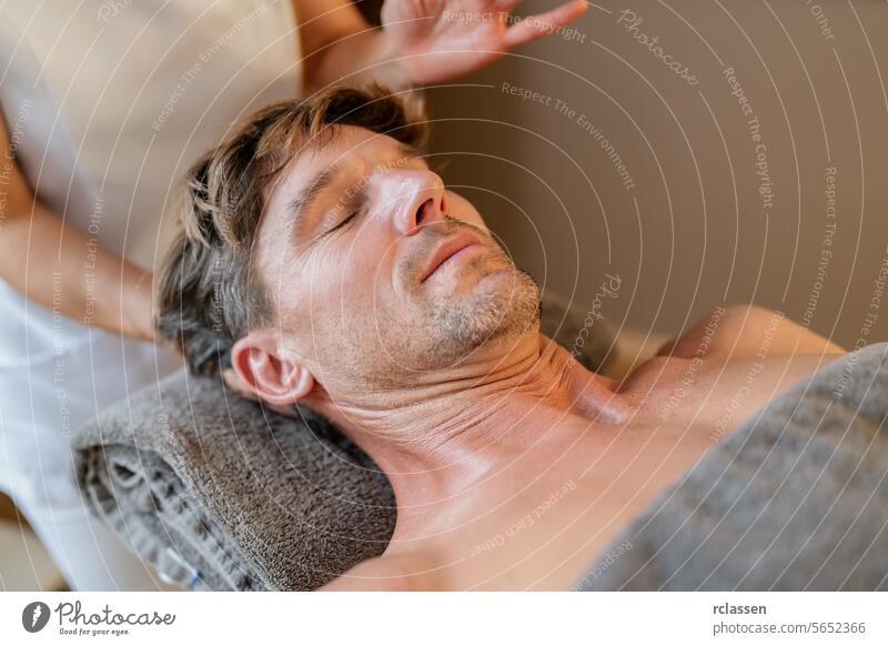 Entspannter Mann, der eine Nackenmassage von einem Therapeuten mit verschwommenen Händen erhält Physiotherapeutin Hotel Massageöle asiatisch Mann entspannt sich