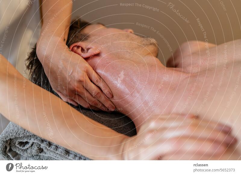 Nahaufnahme eines Mannes, der von einem Therapeuten eine ausführliche Nackenmassage erhält. Wellness Hotel Konzeptbild. Massageöle Klinik asiatisch Erholung