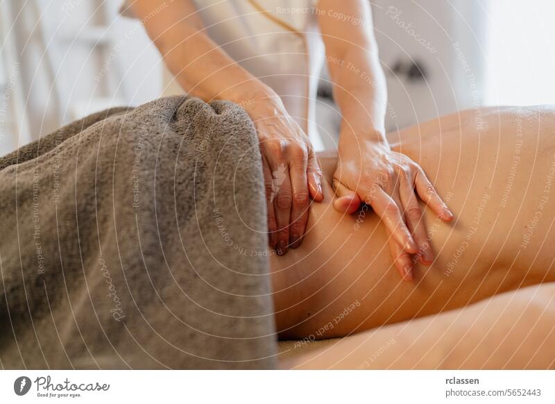 Nahaufnahme der Hände eines Therapeuten, der eine Rückenmassage an einem bedeckten Kunden durchführt Schönheitssalon Massageöle Physiotherapeutin