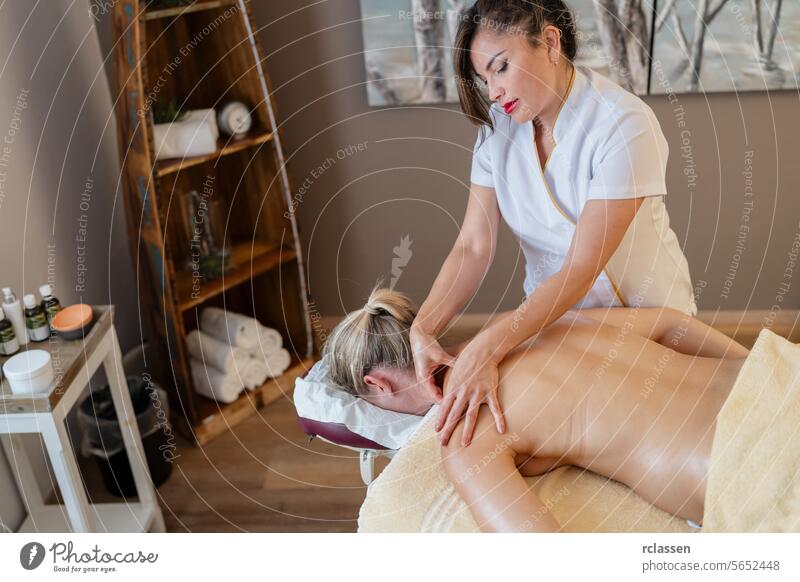 Asiatische Massage Therapeutin gibt Rückenmassage für weibliche Kunden in Spa-Einstellung. Schönheitssalon Wellness Hotel Konzeptbild asiatisch Massagetherapie