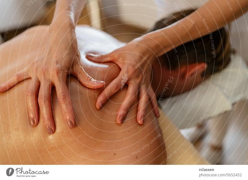 Nahaufnahme eines Massagetherapeuten, der Druck auf den Rücken eines Kunden ausübt. Schönheitssalon Wellness Hotel Konzeptbild Klinik Massageöle