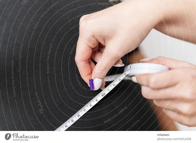 Hände mit einem Maßband auf einem schwarzen weiblichen Torso für eine Gesundheitsanalyse. Fitness und Gesundheit Konzept Bild Fett schlank Diät Gewicht Verlust