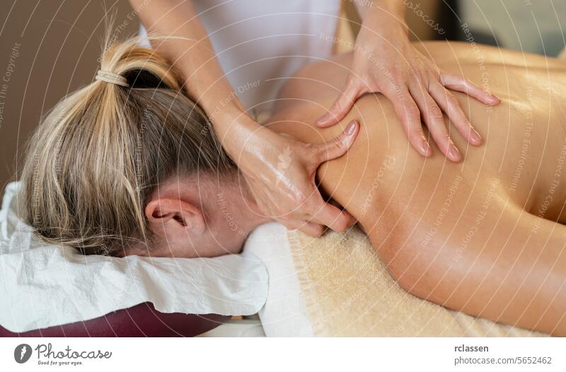 Massage Therapeut Anwendung Schulter und Rücken Massage auf eine liegende Frau. Schönheitssalon Wellness Hotel Konzeptbild Massageöle Physiotherapeutin