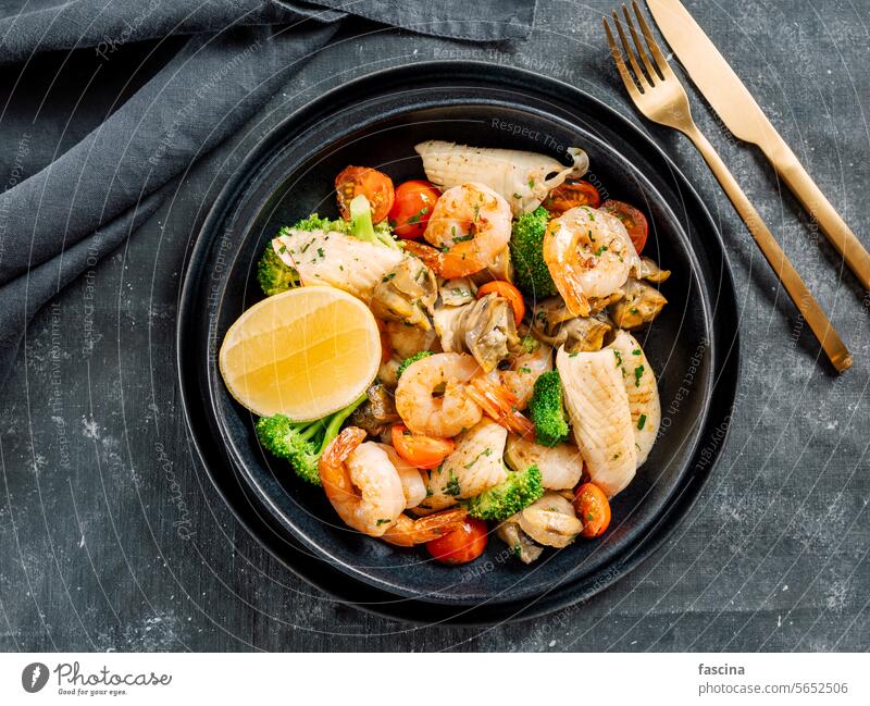 Salat mit gemischten Meeresfrüchten auf dunklem Teller Platte Salatbeilage enthalten Garnelen Muscheln Meeresfrüchte-Gericht Kalamari Tintenfische Fisch