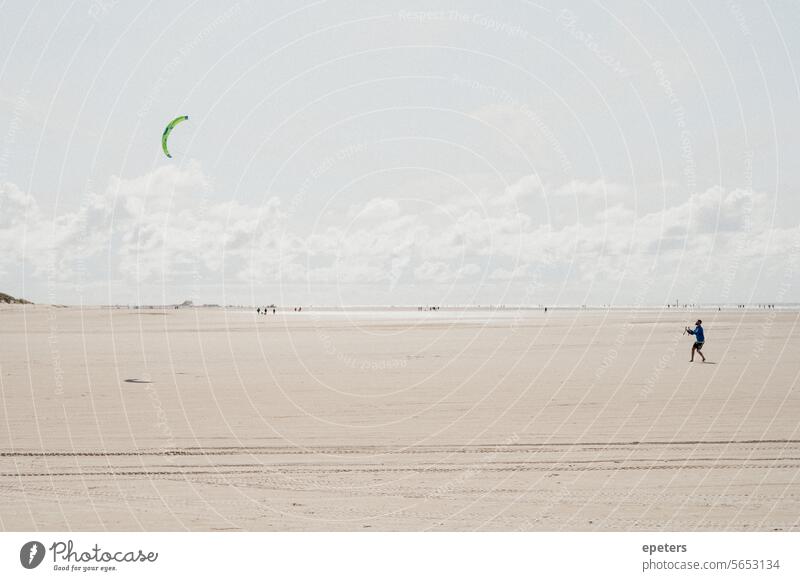 Mann lässt einen Lenkdrachen am Strand von Sankt Peter-Ording steigen Flugdrachen Winddrachen Kite fliegen Drachenfliegen Hoffnung Leichtigkeit Freiheit Symbol