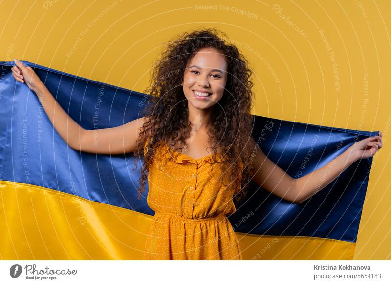 Frau mit ukrainischer Nationalflagge. Ukraine, Patriot, Sieg Krieg Feier Transparente schön zu feiern heiter clever Kultur lockig behaart osteuropa Bildung