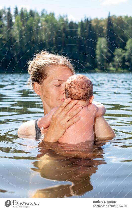 Mutter schwimmt mit ihrem kleinen Mädchen in einem Sommersee Gewöhnung junger Erwachsener Akklimatisierung im Freien alternativ Baby Bad baden Baden Camping
