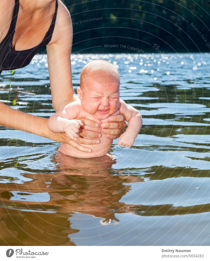 Mutter badet Säugling im Freien Gewöhnung junger Erwachsener Akklimatisierung alternativ Baby Bad baden Baden Camping Kind kalt unzufrieden Mädchen Aushärtung