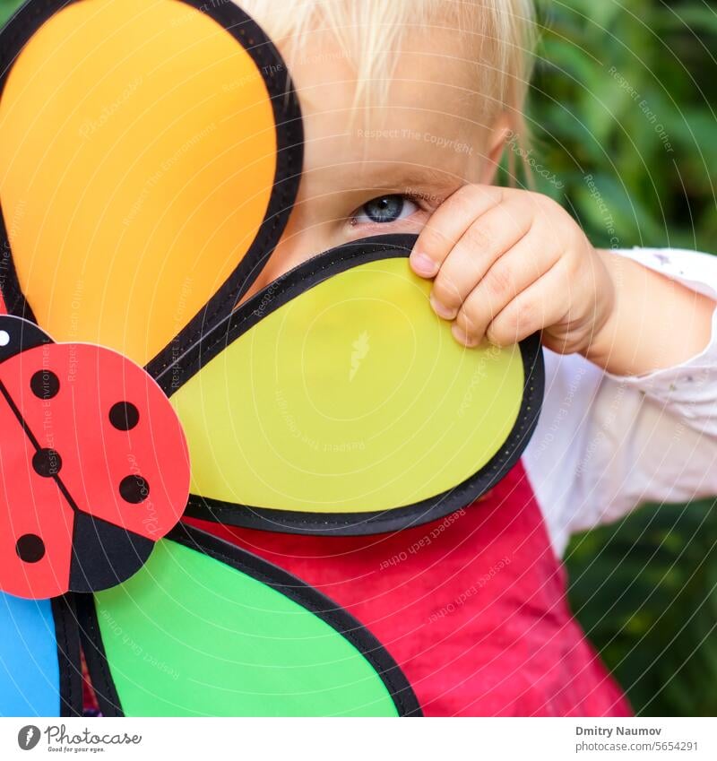 Porträt des niedlichen kleinen Mädchens versteckt hinter Blume Spielzeug im Freien 2 Jahre attraktiv schön hinten blond Kaukasier Kind Kindheit Gesicht Spaß