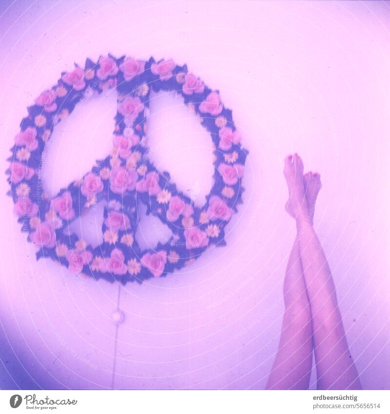 Peace and legs - Peacezeichen-Wandlampe und ausgestreckte Frauenbeine in flauen Farben und mit Blaustich Frieden Liebe Beine schlank Blüten Kunstblumen Waden