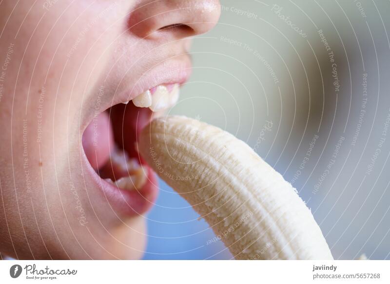 Unerkanntes Mädchen isst köstliche geschälte Banane zu Hause essen Offener Mund Frucht frisch lecker Gesundheit Ernährung Vitamin Biss Lebensmittel Teenager