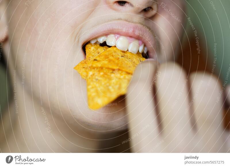Anonymes Mädchen beißt in leckere, knusprige mexikanische Tortilla-Chips essen knirschen Biss Offener Mund Knusprig ungesund nachos Snack gebraten geschmackvoll