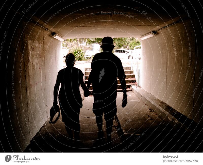 Abkürzung durch den Fußgängertunnel Wege & Pfade Unterführung Architektur Durchgang Paar Gegenlicht Silhouette Tunnelblick Schatten Kontrast Treppe Symmetrie
