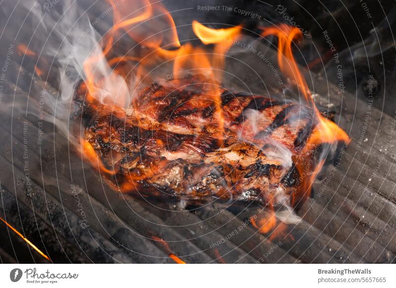Ribeye-Steaks auf dem Grill anbraten und räuchern ribeye Rippenauge Rindfleisch roh marmoriert Fleisch Grillrost grillen Barbecue Feuer Flamme Rauch durchsuchen