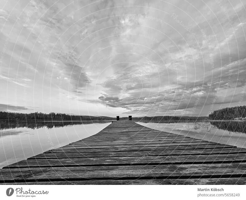 Holzsteg, der in einen schwedischen See hineinragt, in schwarz-weiß. Naturfotografie Baden Abend schön Abenddämmerung Nebel reisen Windstille Landschaft