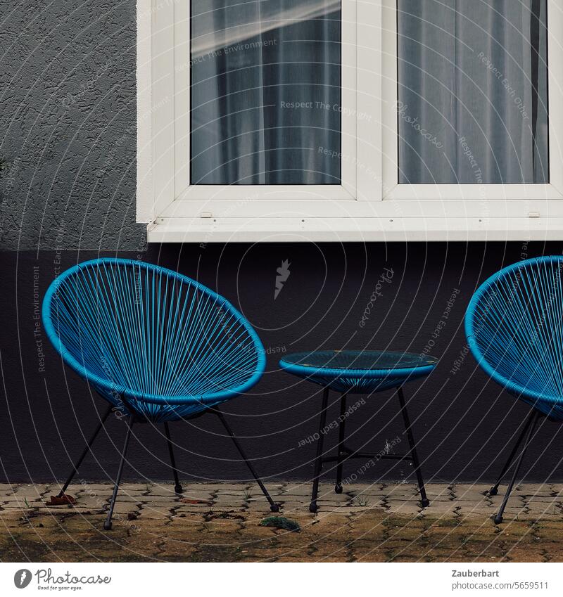 Zwei blaue Korbstühle stehen traurig auf einem Hof, dahinter Fenster Korbstuhl Geflecht graphisch einladend setzen sitzen hinsetzen Stuhl Gartenstuhl