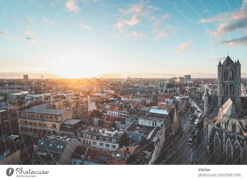 Beobachtung des Sonnenuntergangs über Gent vom historischen Turm im Stadtzentrum aus. Romantische Farben am Himmel. Rotes Licht erleuchtet Gent, Region Falnders, Belgien