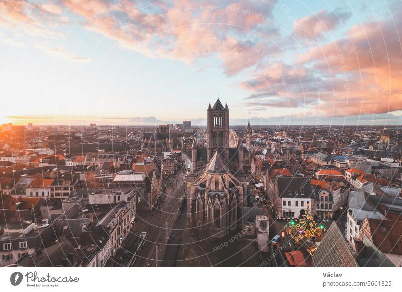 Beobachtung des Sonnenuntergangs über Gent vom historischen Turm im Stadtzentrum aus. Romantische Farben am Himmel. Rotes Licht erleuchtet Gent, Region Falnders, Belgien