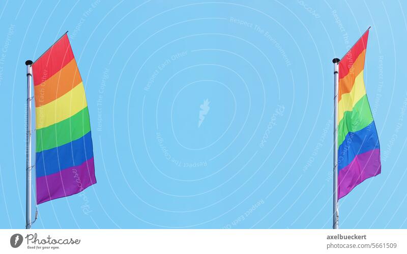 zwei vertikale Regenbogen- oder Lgbtq-Stolzflaggen wehen am Fahnenmast gegen blauen Himmel mit Kopierraum Regenbogenflagge lgbt schwul lgbtq Stolz-Monat Fliege