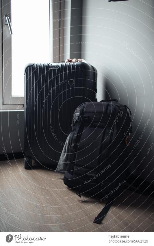 schwarzes Reisegepäck bestehend aus Koffer und Rucksack in Hotelzimmer reisegepäck Neutraler Hintergrund Gepäck Ausrüstung packen bereit sein Abenteuer Aufbruch