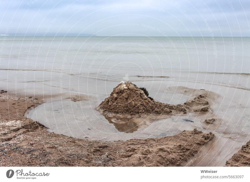 Ein leerer Strand bei bewölktem Wetter im Herbst mit Spuren früherer Besucher Sand Meer Adria Mittelmeer Italien Marina Ravenna See Sandburg Graben Wasser Regen