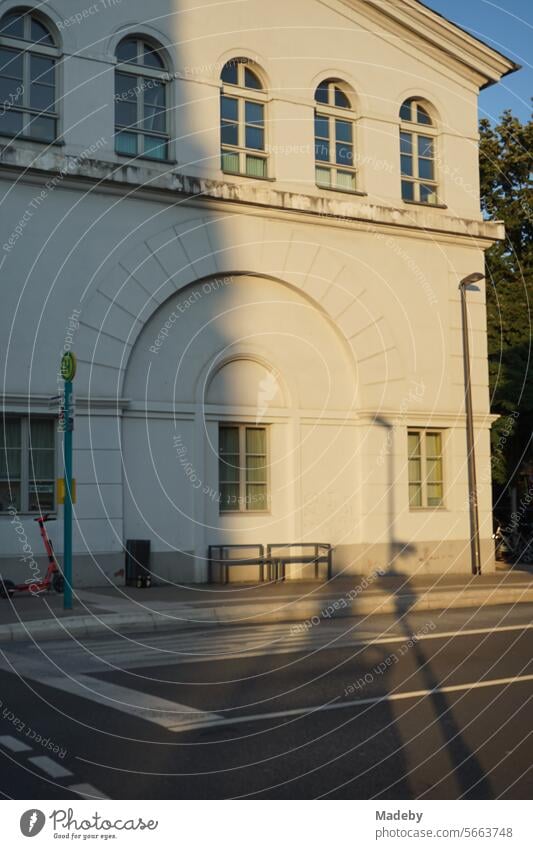 Altes weißes Gebäude mit Rundbogen und Sprossenfenster im Licht der Abendsonne mit Bushaltestelle am Affentorplatz im Stadtteil Sachsenhausen in Frankfurt am Main in Hessen