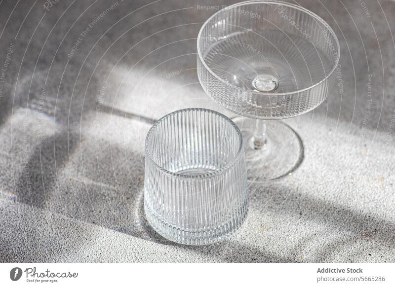 Elegante Glaswaren werfen Schatten auf strukturierter Oberfläche Licht Textur Cocktail Gaukler elegant Kristalle übersichtlich natürlich weich Casting