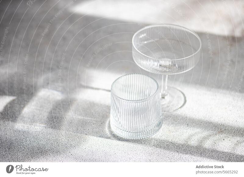 Elegante Glaswaren in sanftem Sonnenlicht und Schatten Licht Textur elegant weich spielen Oberfläche Spielfigur texturiert Tisch Dekor heimwärts Innenbereich