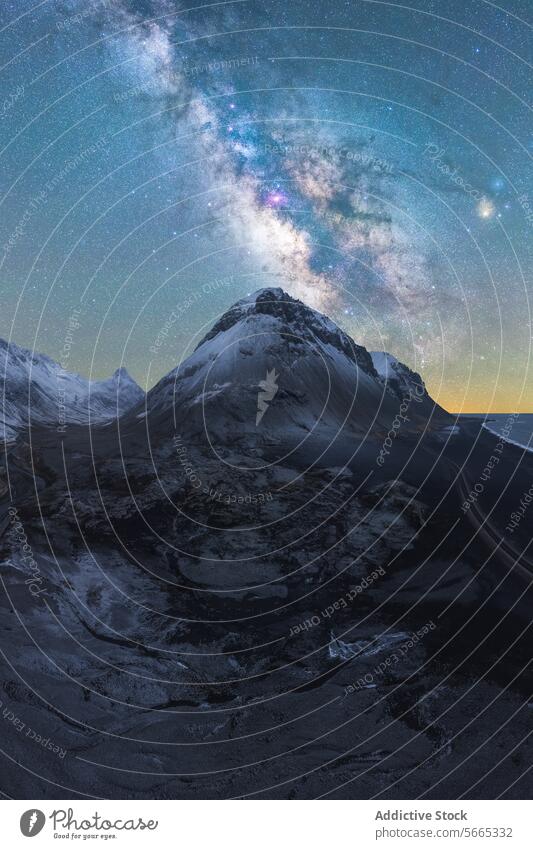 Majestätischer, schneebedeckter Berggipfel unter dem kosmischen Schein der Milchstraße in einer klaren isländischen Winternacht Island Milchstrasse