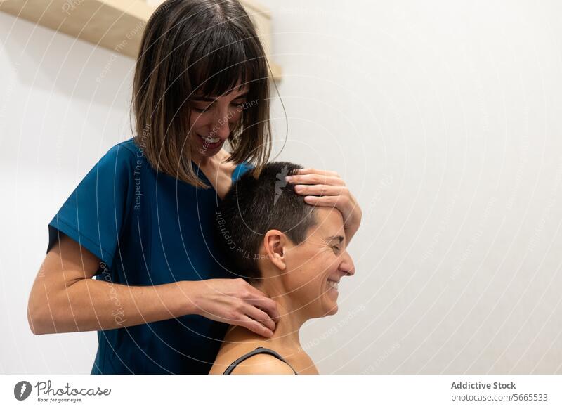 Entspannende Kopfmassage durch einen professionellen Therapeuten Frau blau bürsten Lächeln Empfänger Erholung Wohlbefinden Massage Freude Komfort Therapie