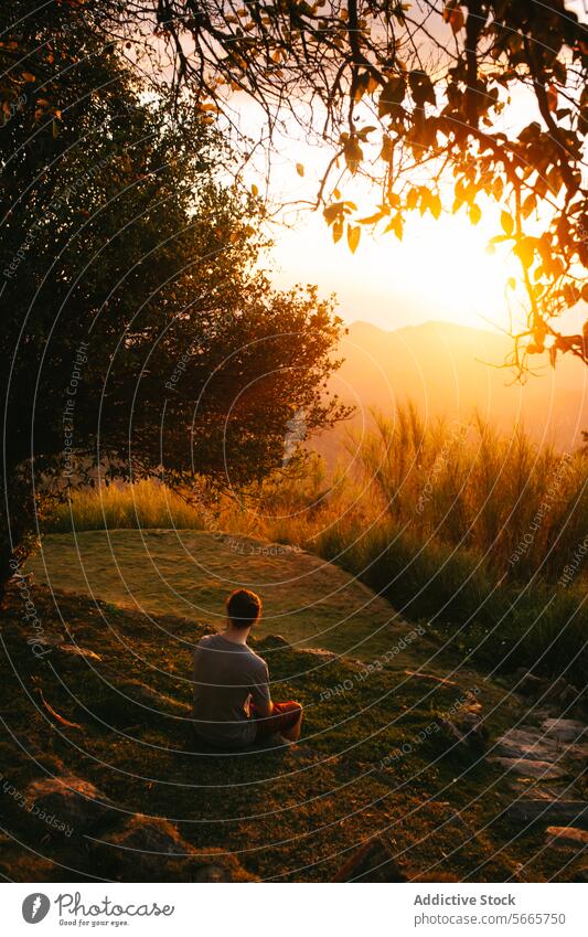 Gelassene Meditation bei Sonnenuntergang in der Natur in Minca, Kolumbien Person Gelassenheit Ruhe goldene Stunde Landschaft friedlich grasbewachsener Hügel