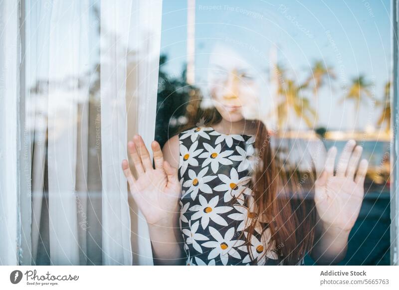Junge Frau schaut durch ein Fenster mit Palmenreflexion Reflexion & Spiegelung nachdenklich Starrer Blick Glas Hand Presse Unschärfe Hintergrund ruhig Umwelt