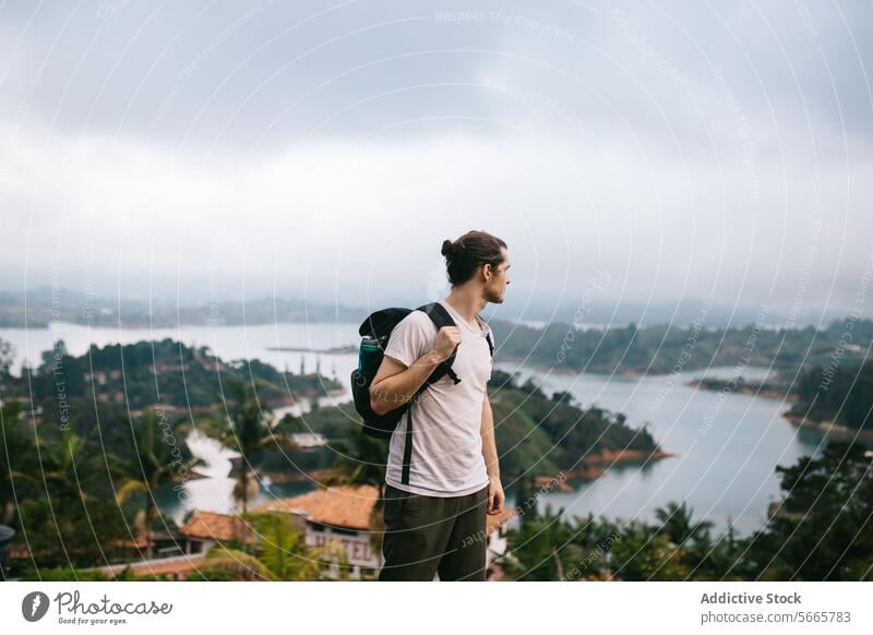 Reisende mit Rucksack mit Blick auf einen nebligen See in Guatapé Reisender Nebel Landschaft Abenteuer Kontemplation männlich malerisch Ansicht Natur im Freien