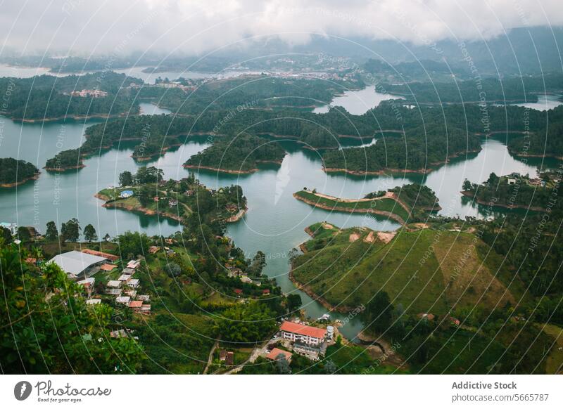 Neblige Seenlandschaft mit üppigem Grün und Siedlungen in Guatapé Landschaft Antenne Ansicht neblig grün Halbinseln bewaldet Hügel Gelassenheit Wasser