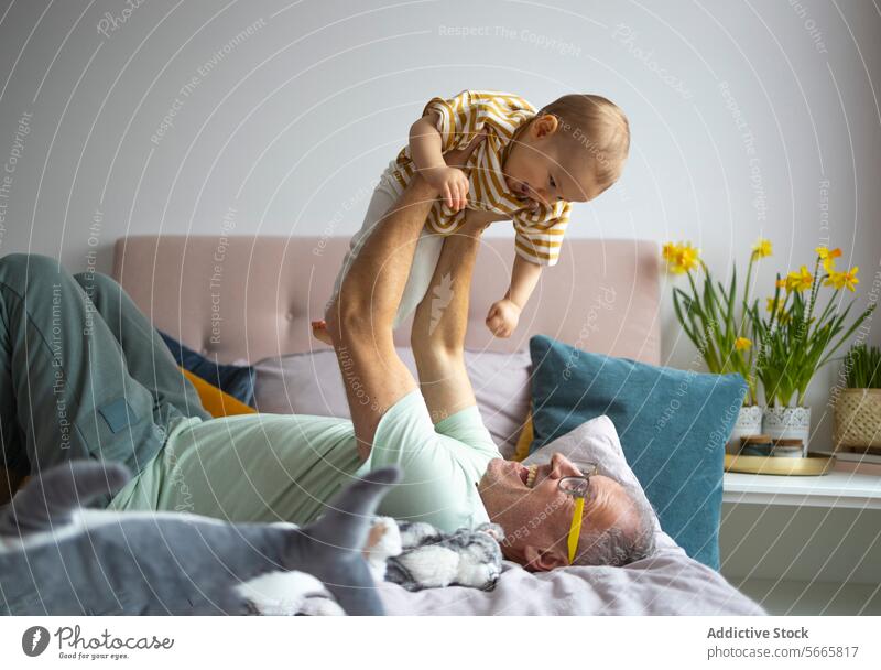 Großvater und Enkelkind genießen die spielerische Zeit im Haus spielen Freude Lächeln Familie Bonden im Innenbereich Schlafzimmer Kleinkind Fröhlichkeit