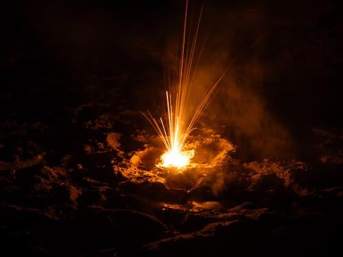 Feuerwerk sprüht Funken und erhellt die umgebende Erde Explosion Qualm Rauch Energie heiß Nacht Pyrotechnik Effekte Licht Silvester u. Neujahr Lichterscheinung