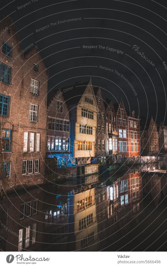 Blick auf klassische mittelalterliche Häuser, die sich in einem Wasserkanal im Zentrum von Gent, Region Flandern, Belgien, spiegeln. Bunte Fassaden der Häuser reicher Bürger